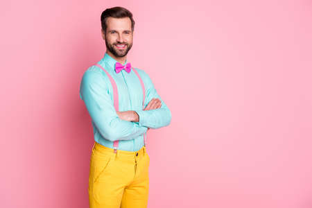 Profile photo of handsome guy trend clothes red carpet celebrity arms crossed photographing posing wear shirt suspenders bow tie yellow pants isolated pastel pink color backgroundの写真素材