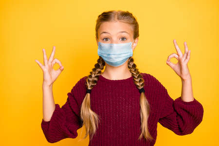 Close-up portrait of nice attractive charming lovely pre-teen girl wearing gauze mask showing...