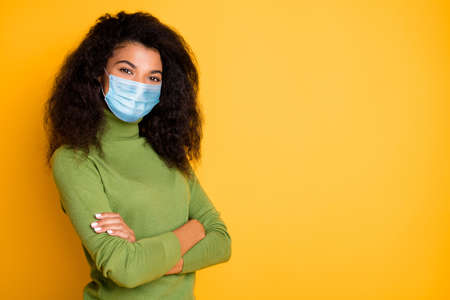 Profile side view portrait of nice attractive wavy-haired girl folded arms wearing safety mask mers cov prevention pandemia empty space isolated vibrant yellow color backgroundの写真素材