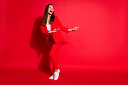Full length photo of attractive funny lady successful worker having fun dance party colleagues event meeting good mood wear blazer suit pants shoes isolated red color backgroundの写真素材