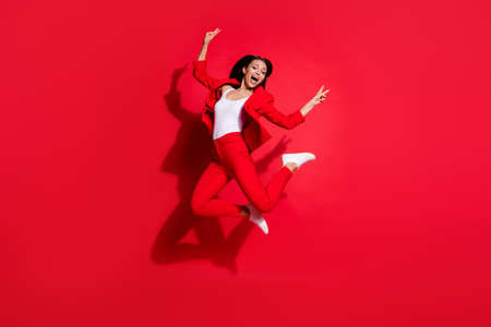 Full length photo of attractive lady having fun jumping high up good mood showing v-sign symbols...