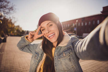 Self-portrait of her she nice attractive pretty trendy positive funky cheerful cheery brown-haired girl spending weekend free time traveling October showing v-sign having funの写真素材