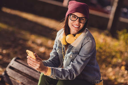 Portrait of her she nice attractive pretty cheerful cheery girl blogger using device browsing media multimedia post social network blogging spending sunny day October free time outdoor outsideの写真素材