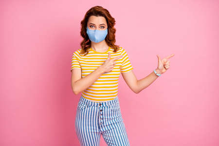 Portrait of nice attractive healthy wavy-haired girl wearing reusable textile mask demonstrating...