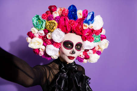 Closeup photo of funny folklore witch creature character death day facial creepy makeup masquerade mexican holiday make take selfies wear floral headwear costume isolated violet backgroundの写真素材