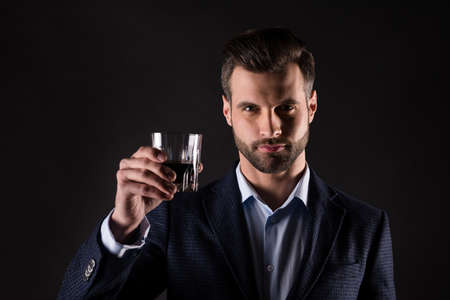 Close-up portrait of his he nice attractive content successful guy sales manager agent broker employer partner leader drinking cognac occasion isolated on dark black color backgroundの写真素材