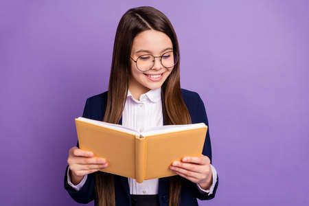 Close-up portrait of her she lovely focused brainy long-haired pre-teen girl schoolchild reading home task homework diary isolated bright vivid shine vibrant lilac violet color backgroundの写真素材