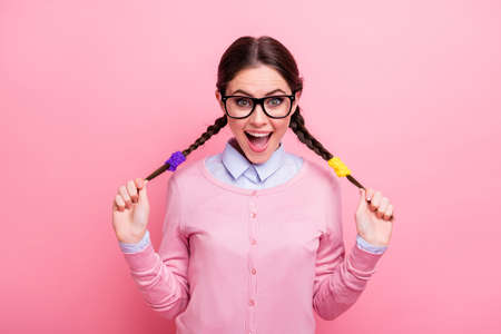 Close-up portrait of her she nice attractive pretty lovely positive cheerful cheery brown-haired teen girl having fun touching tails wearing blouse isolated pink pastel color backgroundの写真素材