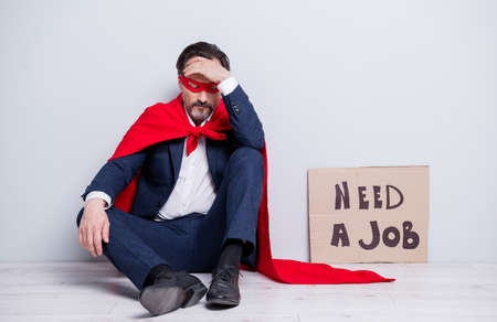 Full length photo of stressed mature aged fired business guy super hero costume sit floor placard...