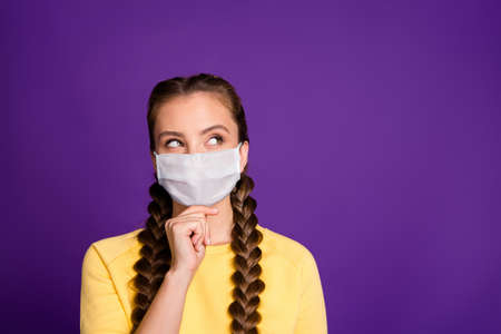 Close-up portrait of nice attractive curious girl wearing safety mask thinking symptom syndrome contamination therapy copy space isolated bright purple lilac violet color backgroundの写真素材