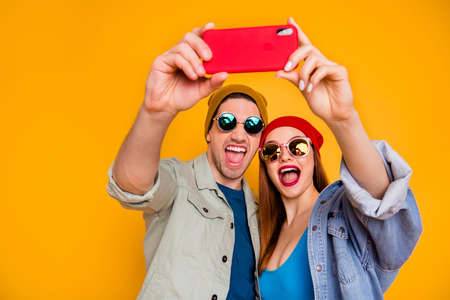 Close-up portrait of his he her she nice attractive cheerful glad couple making taking selfie having fun trip journey travel summer isolated over bright vivid shine vibrant yellow color backgroundの写真素材