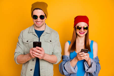 Portrait of positive two people students bloggers man woman use smartphone texting typing social...