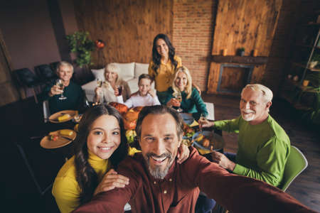 Self-portrait of nice adorable cheerful positive big full family small little kids meeting gathering enjoying celebration tradition hugging at modern loft industrial brick interior house flatの写真素材