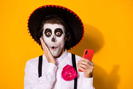 Close-up portrait of his he nice painted creepy worried stunned wondered amazed guy caballero using gadget browsing fake news post isolated bright vivid shine vibrant yellow color backgroundの写真素材