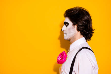 Profile photo of creepy monster ghost guy look empty space waiting funeral ceremony graveyard wear white shirt rose sugar skull death costume suspenders isolated yellow color backgroundの写真素材