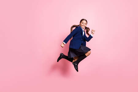 Full length body size view of her she nice attractive pretty glad cheerful cheery small little girl jumping running rush first lesson isolated over pink pastel color backgroundの写真素材