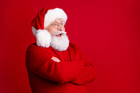 Profile side photo of positive excited old man in santa claus headwear cross hands enjoy rejoice...