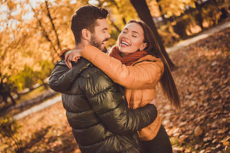 Photo of passionate bonding couple guy hug cuddle laughing girlfriend in fall october foliage park...