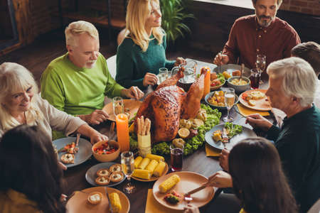 Cropped photo holiday table family relatives gathering thanks giving dinner communication talk living room indoorsの写真素材
