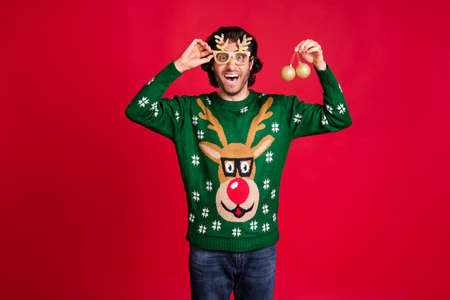 Portrait of his he nice attractive amazed glad cheerful cheery guy wear childish specs holding in hands tiny tree toys preparing having fun isolated bright vivid shine vibrant red color backgroundの写真素材