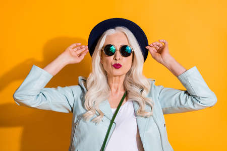 Portrait of stunning charming old lady touch her retro hat enjoy valentine day date send air kiss wear good look clothes isolated over bright color backgroundの写真素材