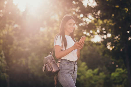 Portrait of her she nice attractive pretty lovely cheerful cheery focused girlfriend using device gadget 5g app browsing media multimedia fresh air spending time sunlightの写真素材