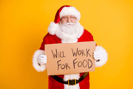 Portrait of nice jobless fired serious white-haired Santa holding in hands paper card promo seeking...