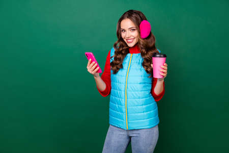 Photo of cute charming young lady hold cup drink coffee to-go beaming smiling log-in social network...