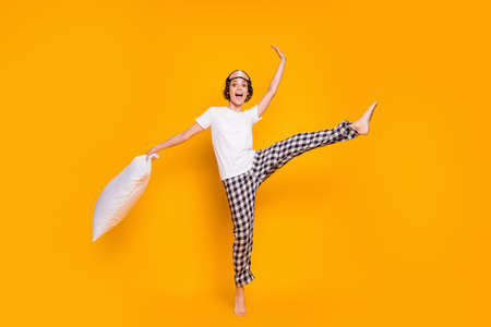 Full body photo of cheerful lady hold big pillow wake up playful mood dancing energetic raise leg up...