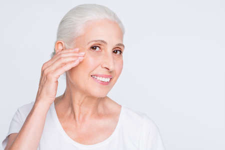 Close-up portrait of nice attractive cheerful cheery content experienced gray-haired lady smoothing...