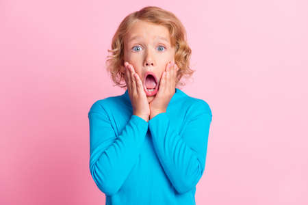 Photo of little child arms palms cheekbones scared open mouth wear blue turtleneck isolated pastel...