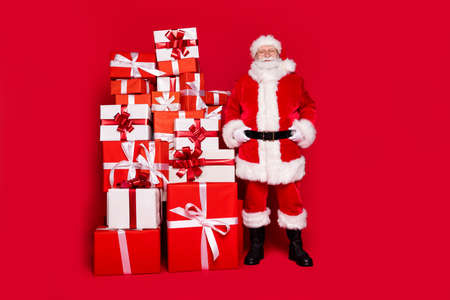 Full length body size view of his he handsome content fat cheery Santa pile stack gifts newyear shop store center mall boutique occasion isolated bright vivid shine vibrant red color backgroundの写真素材