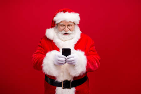 Portrait of his he nice attractive handsome cheerful cheery focused Santa using gadget 5g fast speed...
