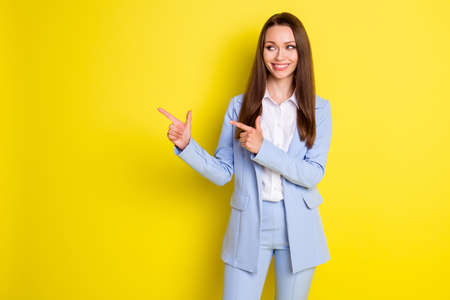 Photo of positive girl marketer expert point index finger copyspace demonstrate company adverts wear style blazer trousers isolated over bright shine color backgroundの写真素材