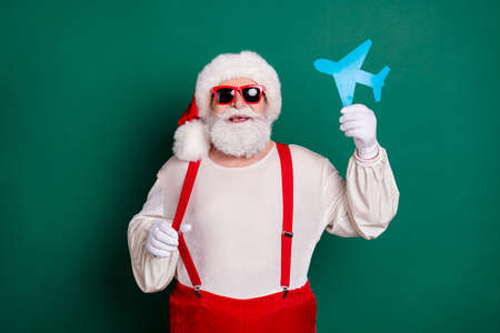 Portrait of his he nice handsome cheerful funky fat overweight Santa holding in hand paper plane...