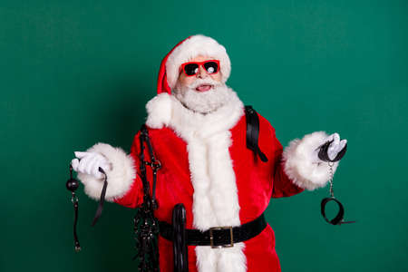Portrait of his he nice attractive cheerful cheery bearded funny Santa father holding in hands equipment tools   pervert game having fun isolated over green color backgroundの写真素材