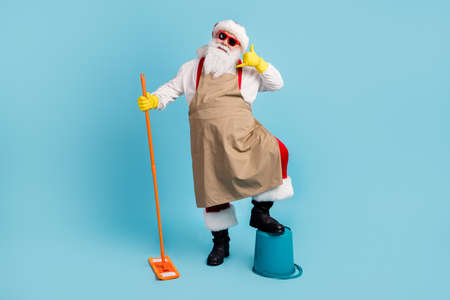 Full length body size view of nice cheerful Santa cleansing floor doing domestic housework duty...