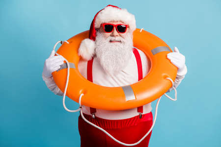 Portrait of his he attractive cheerful cheery confident white-haired Santa father swimmer wearing safe lifesaver leisure rest resort isolated bright vivid shine vibrant blue color backgroundの写真素材