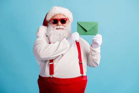 Portrait of his he nice attractive cheery confident overweight thick white-haired Santa holding in hands letter wish list December tradition isolated bright vivid shine vibrant blue color backgroundの写真素材