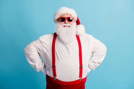Portrait of his he nice attractive cheerful cheery glad content thick white-haired Santa hands on hips holly jolly mood isolated over bright vivid shine vibrant blue color backgroundの写真素材
