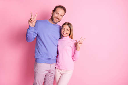 Photo of loving father hug his little girl kid make v-sign wear casual style clothes isolated on pastel color backgroundの写真素材