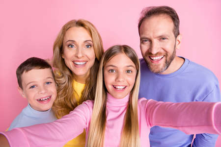 Portrait of positive cheerful girl take selfie her family mom dad brother isolated over pastel color backgroundの写真素材