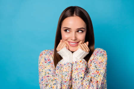 Closeup photo of cute attractive cheerful lady good mood beaming smile long straight hairdo look side empty space arms on chin cheeks wear casual warm sweater isolated blue color backgroundの写真素材