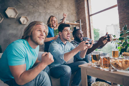 Portrait of four nice attractive cheerful cheery crazy addicted guys playing video game sport cup...