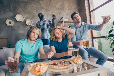 Portrait of addicted football fans four people man sit couch watch national  league match support team lose goal feel sad in house indoorsの写真素材