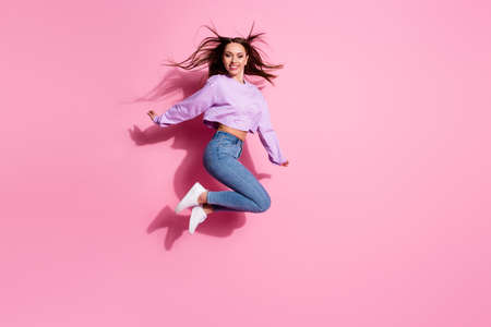 Full body photo of charming lovely girl jump enjoy free time holiday wear good look pullover gumshoes isolated over pink color backgroundの写真素材