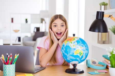 Photo of astonished kid girl study geography remote impressed new continent information scream touch...