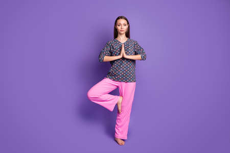 Full length photo of focused girl train yoga workout exercise raise leg put hands together wear pink...