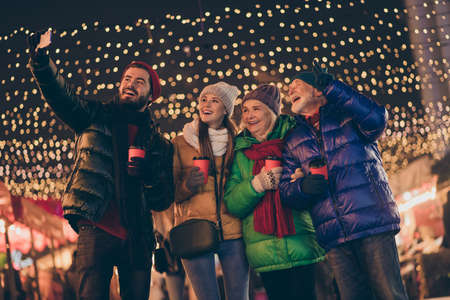 Portrait of nice attractive cheerful family having fun spending time street city urban market...