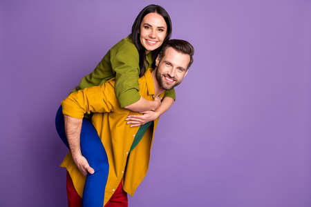 Profile photo pretty lady handsome guy couple carry piggyback meet adventures playful mood spend time quarantine wear casual bright shirts pants outfit isolated purple color backgroundの写真素材
